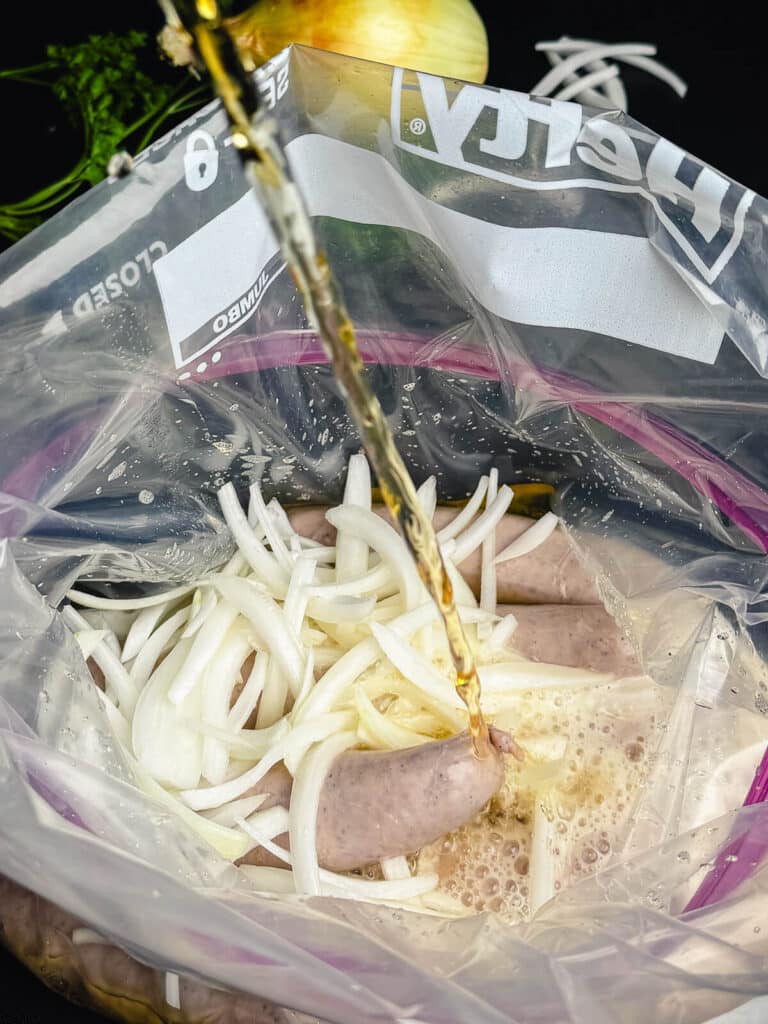 beer being poured into a bag of brats and onions