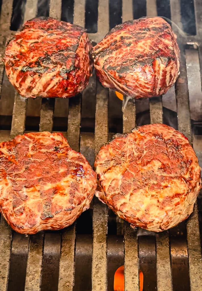 ribeye filets on a grill over flmaes