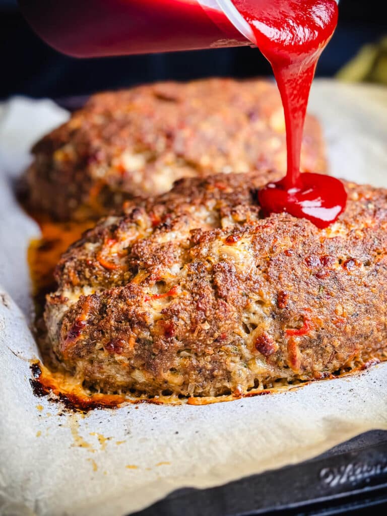 sauce being poured on meatloaf