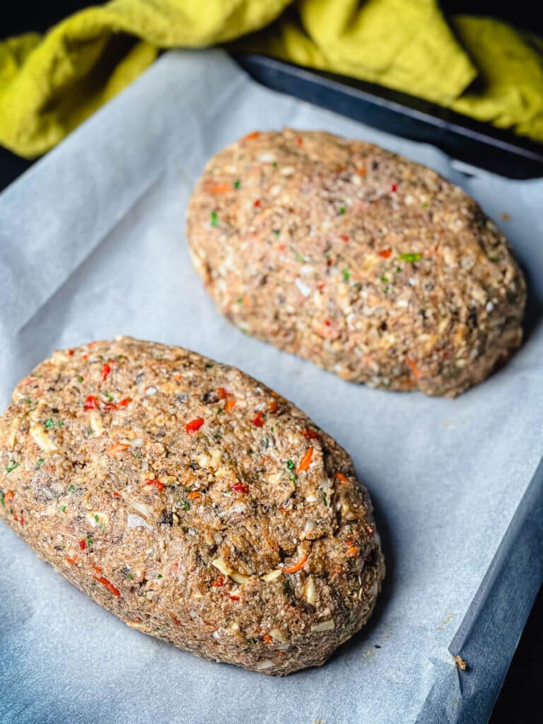 shaped uncooked meatloaf on baking sheet