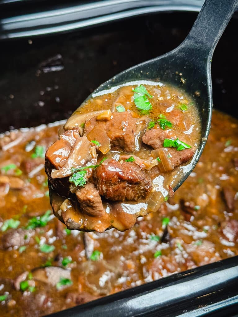 crockpot beef tips with parsley in a slow cooker