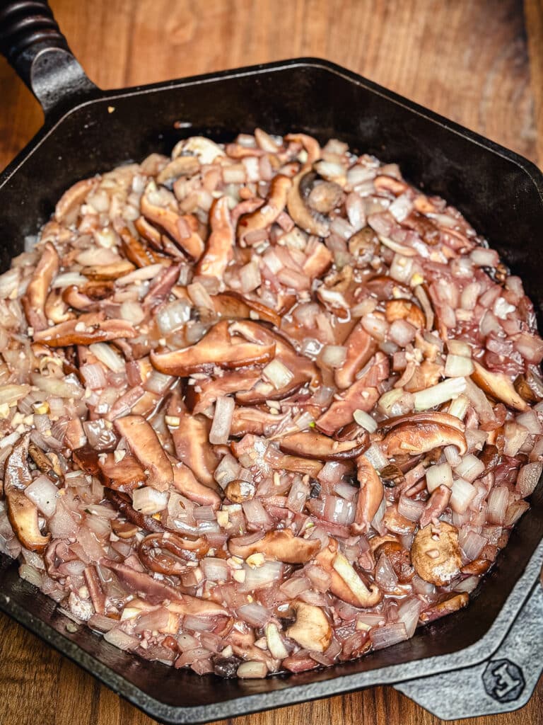 mushrooms and onions in a cast iron pan