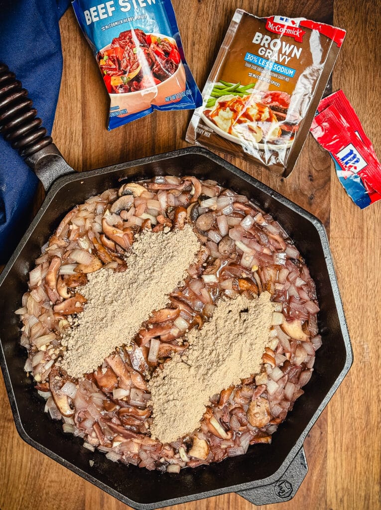 packaged seasoning topping beef tips in a cast iron pan