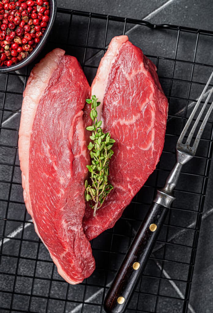 uncooked sirloin steak sitting on a cooling rack