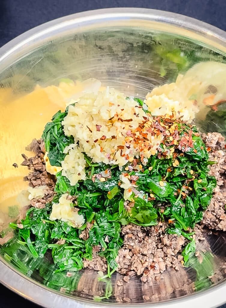 spinach and mushrooms with butter in a mixing bowl