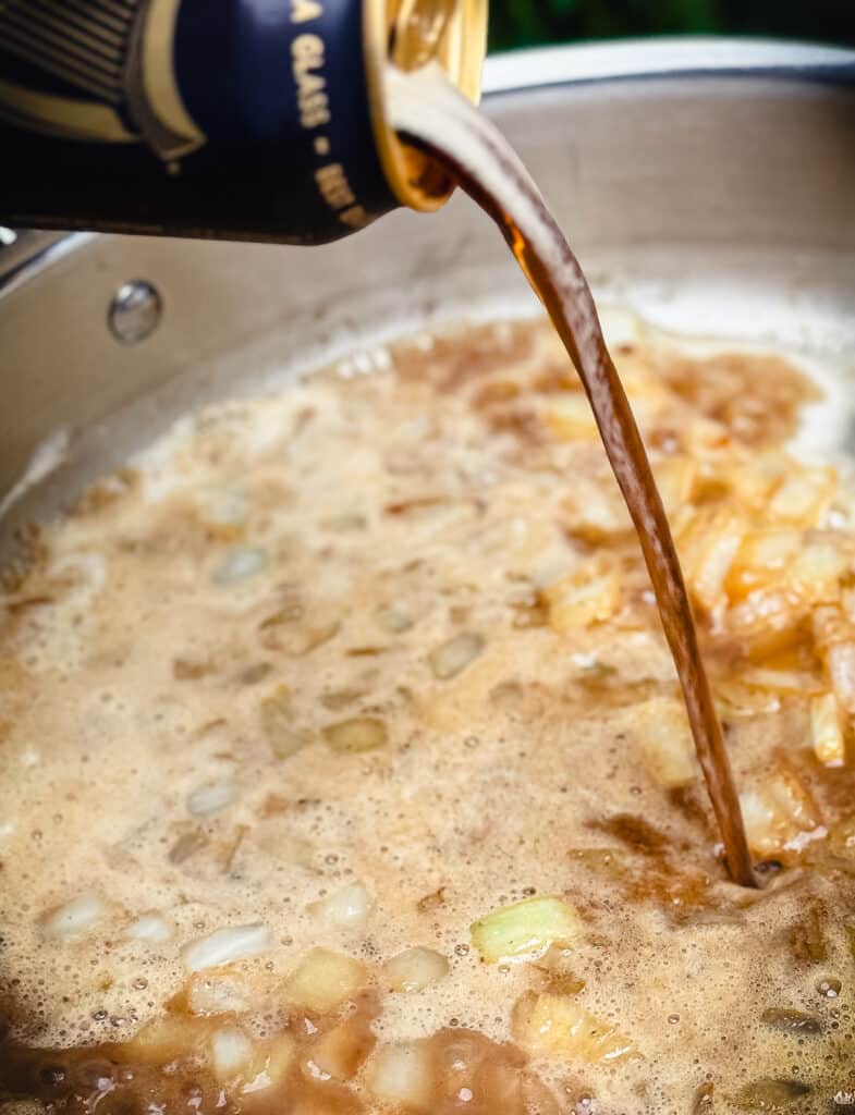 beer being poured into the brother to make irish stew
