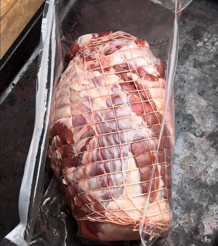 boneless leg of lamb being opened from a package