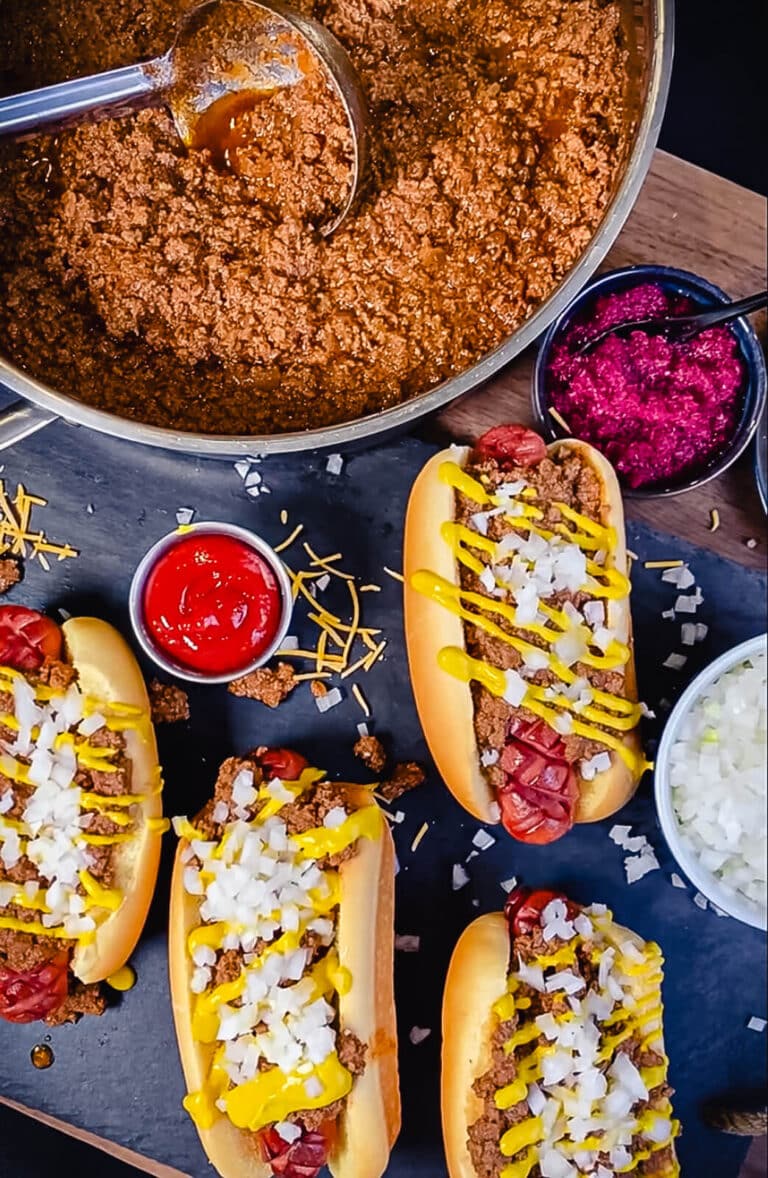 Coney Island hog dog sauce in a pan with some hot dogs in buns