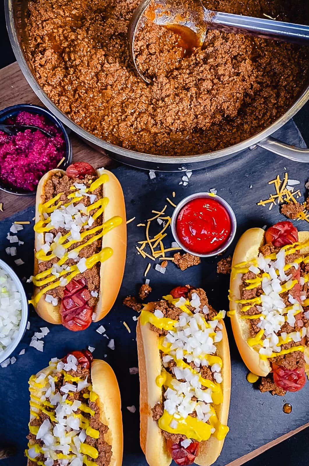 coney island hot dog sauce with hot dogs in the foreground