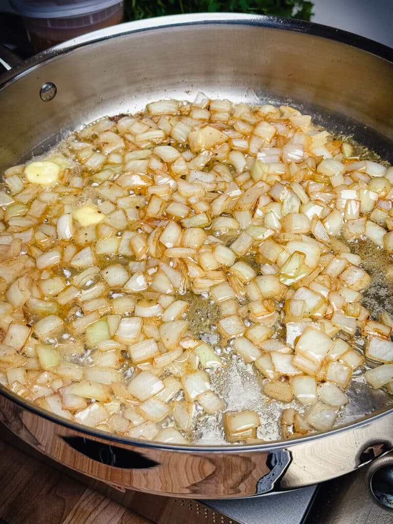 onions cooking in a pan with butter