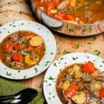 Irish lamb stew in bowls with a pot of stew in the background