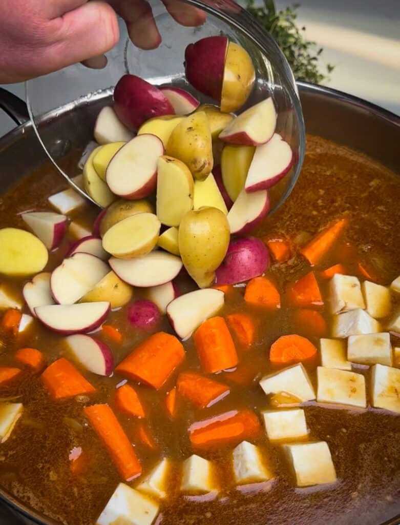 root vegetables being added to stew 