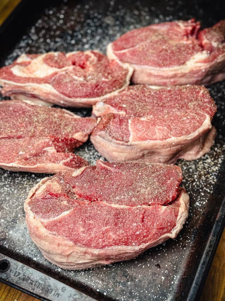 seasoned slices of leg of lamb on a tray