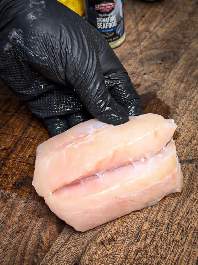 slicing a fish filet to create a pocket for stuffing