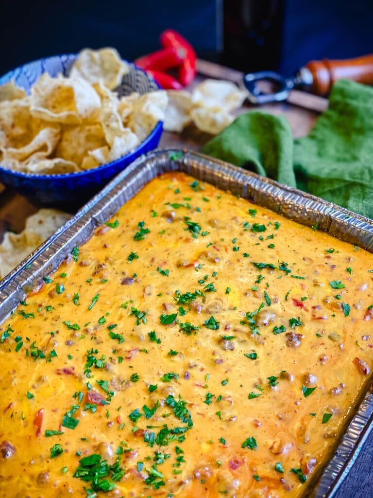 smoked queso dip in a large aluminum pan