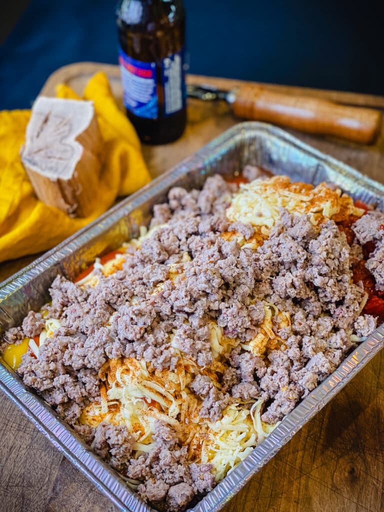 ingredients for smoked queso dip placed into an aluminum pan